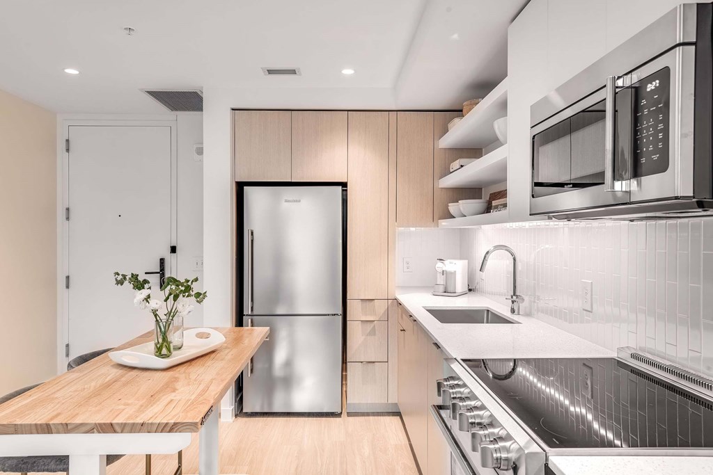 a kitchen with wood cabinetry and white countertops