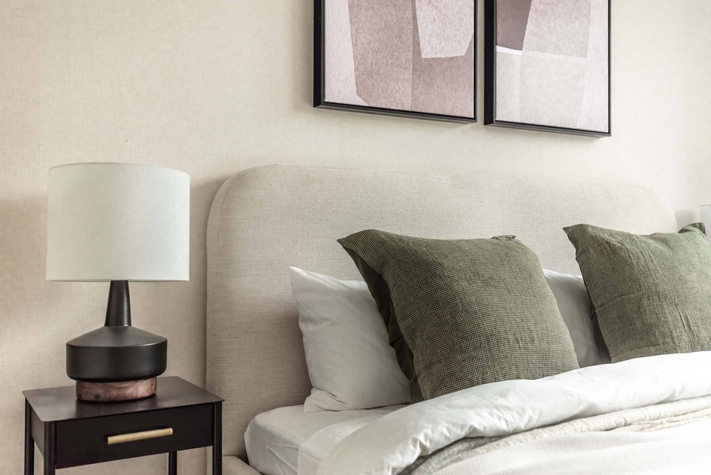 a bedroom with white bedding and green pillows