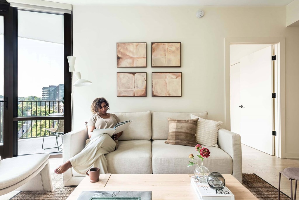 a woman sitting on a couch reading a magazine