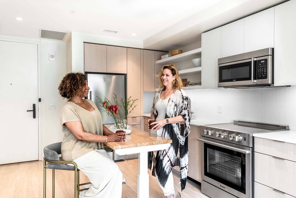 two women standing around a table in a kitchen