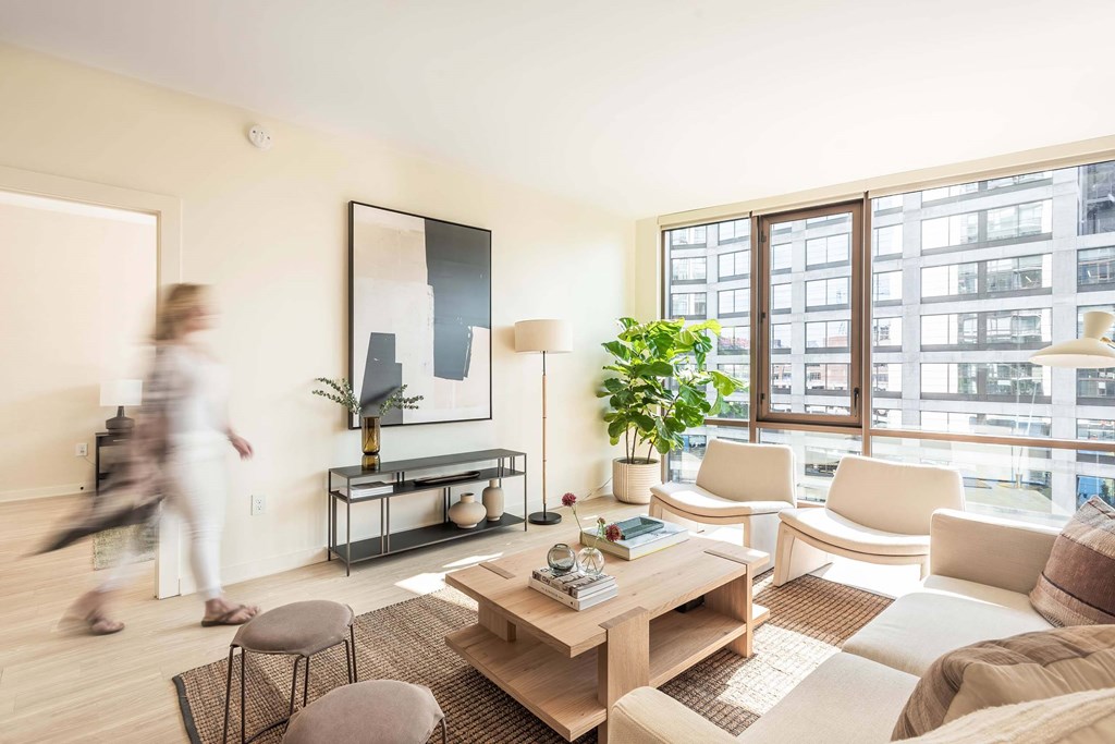 a living room with a large window and a wooden coffee table
