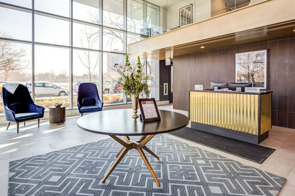 a lobby with a table and chairs and a large window