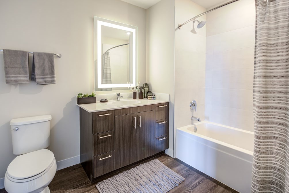 a bathroom with a toilet sink and shower and a mirror