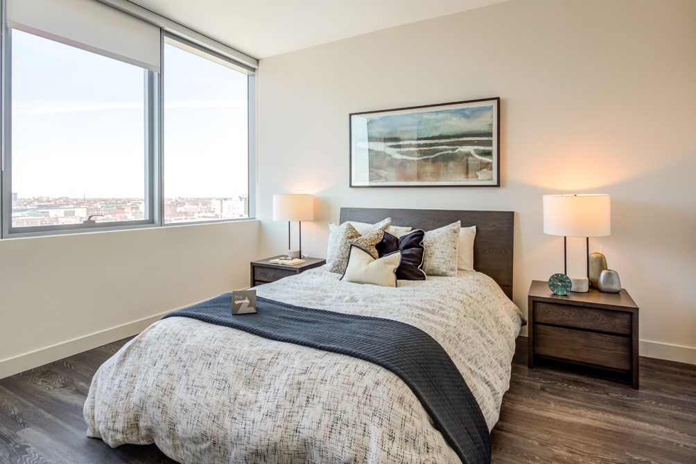 a bedroom with a bed and two windows