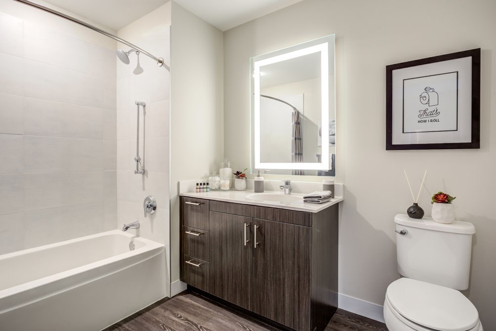 a bathroom with a toilet sink and shower and a mirror