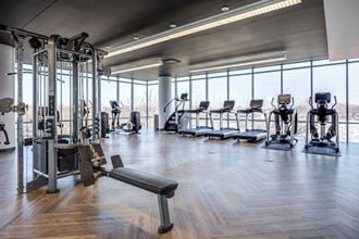 a gym with cardio machines and a view of a window