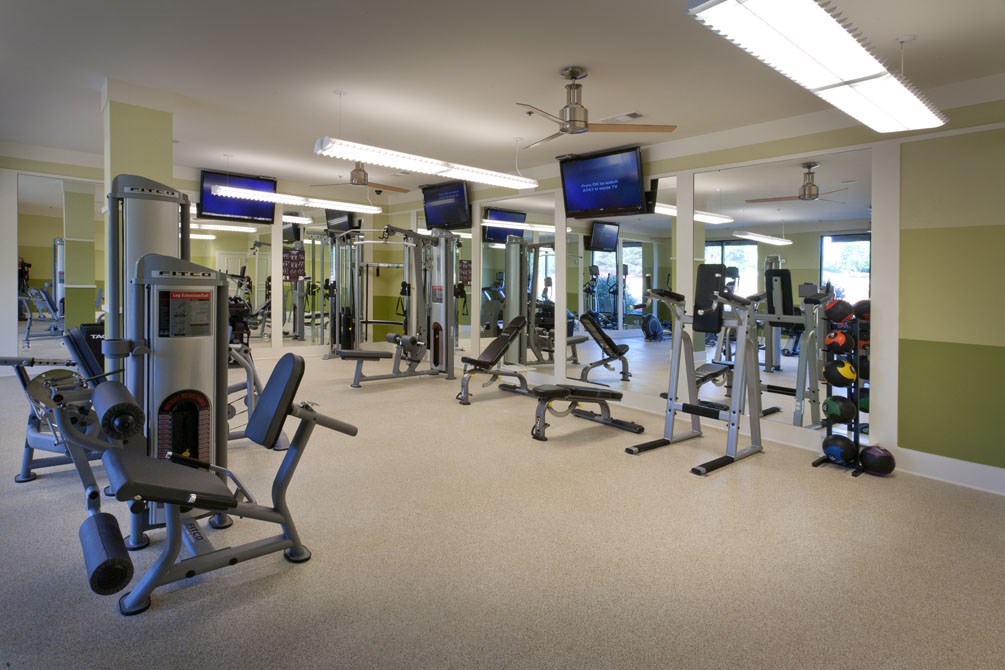a gym with a lot of weights and cardio equipment