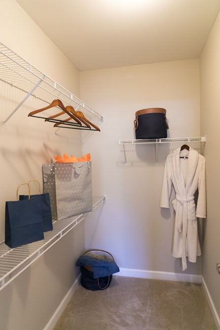 a closet with a white robe and bags and shoes