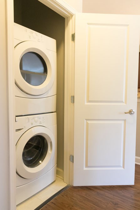 a washer and dryer in a closet with a door