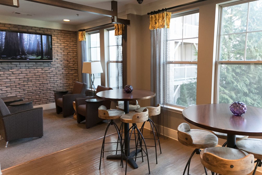 a living room with tables and chairs and a television