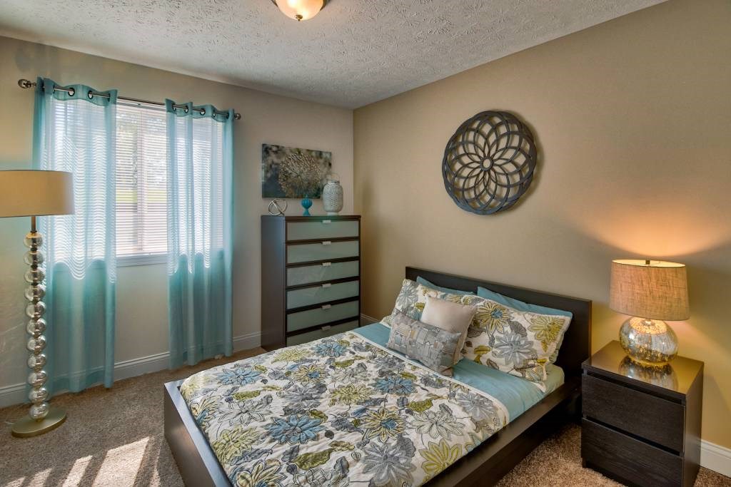 a bedroom with a bed and a dresser and a window