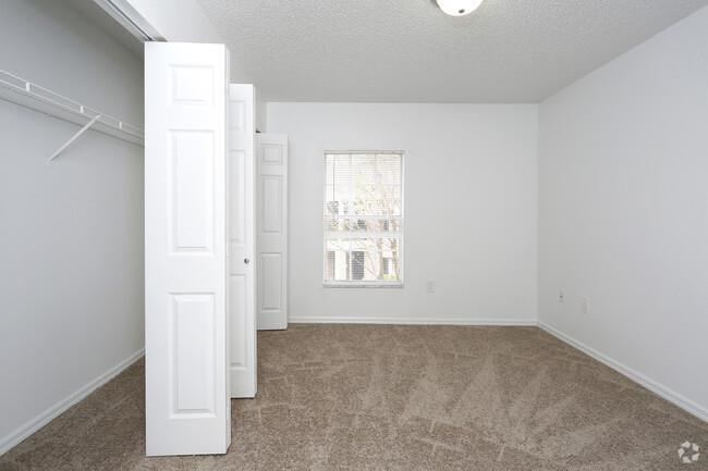 an empty living room with a window and a closet