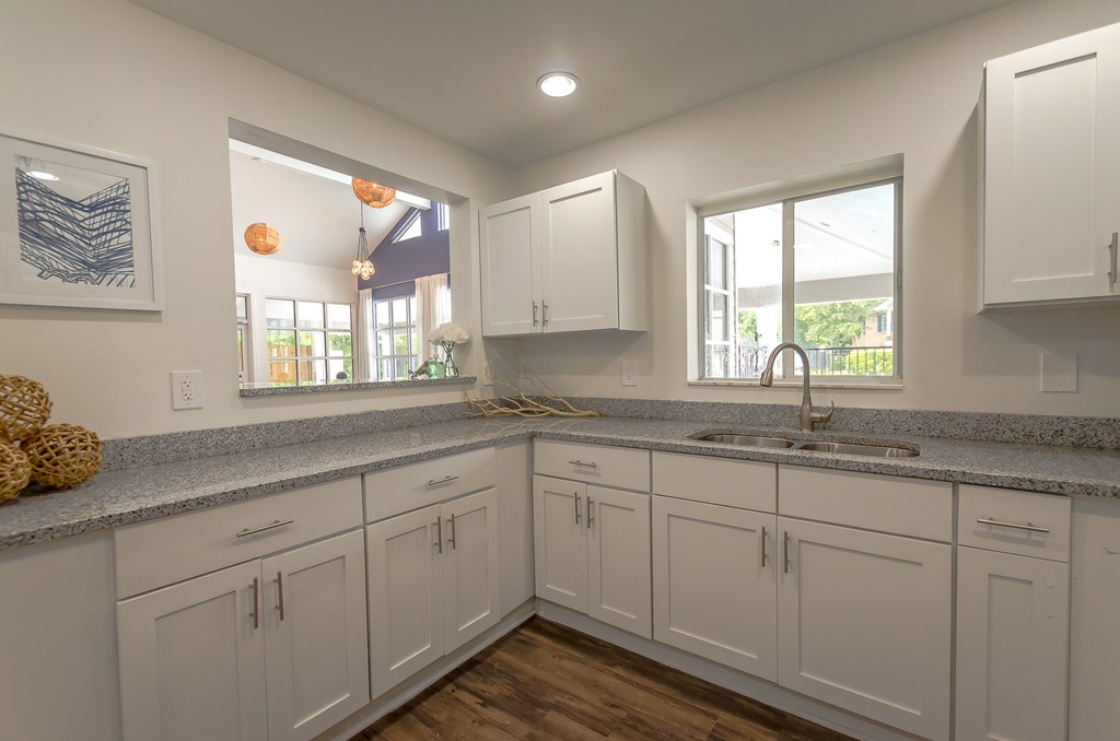 a large kitchen with white cabinets and granite counter tops