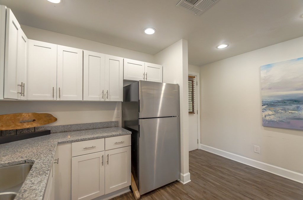 a kitchen with white cabinets and a stainless steel refrigerator