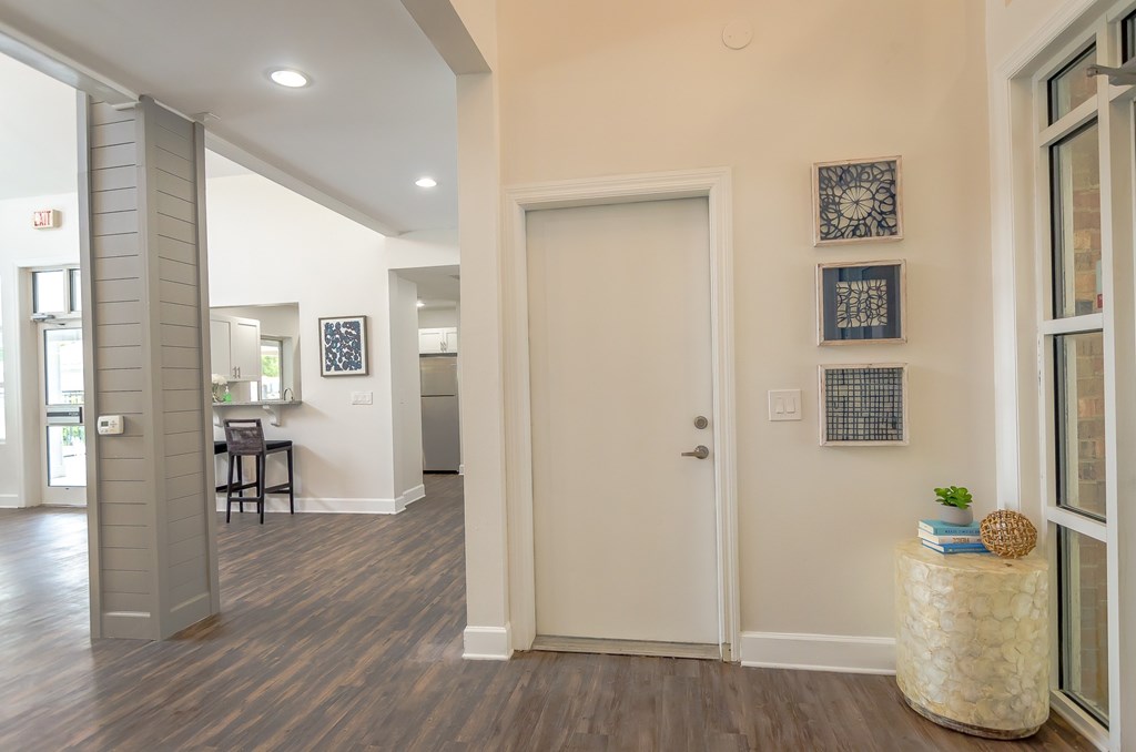 an open living room and hallway with a door to a kitchen