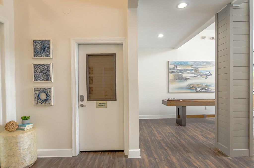 a game room with a pool table and paintings on the wall