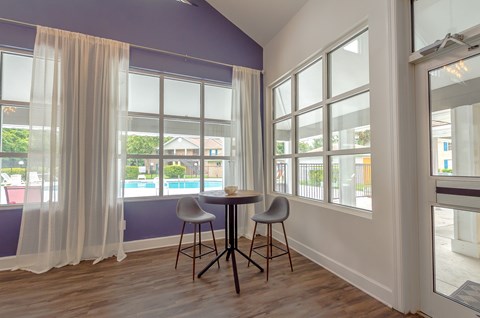 a dining room with a table and two chairs and a window