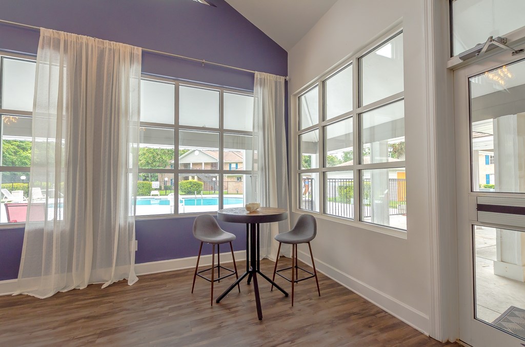 a dining room with a table and two chairs and a window