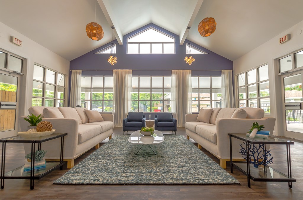 a living room with couches and chairs and a rug