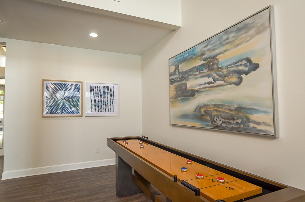 a games room with a pool table and artwork