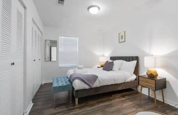 a bedroom with a bed and a table and a mirror