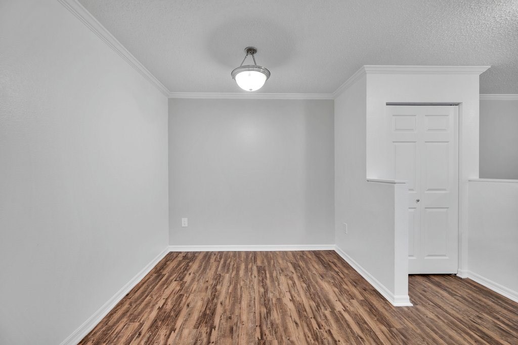 an empty living room with wood flooring and a white door