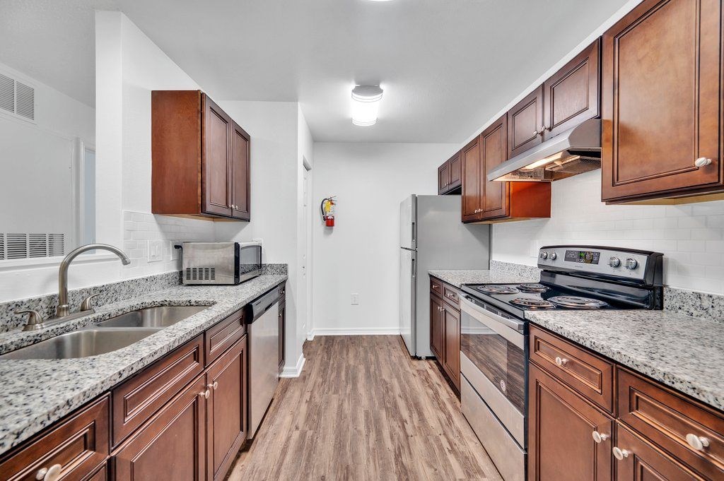 a kitchen with granite counter tops and wooden cabinets