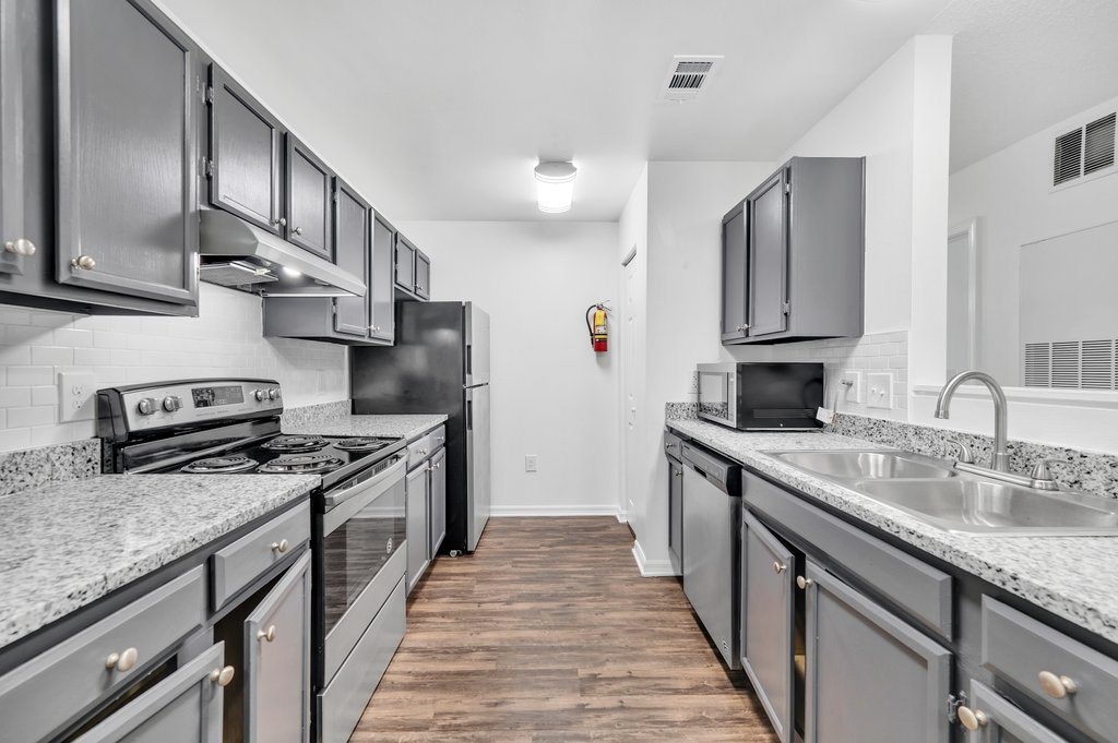 a kitchen with granite counter tops and stainless steel appliances