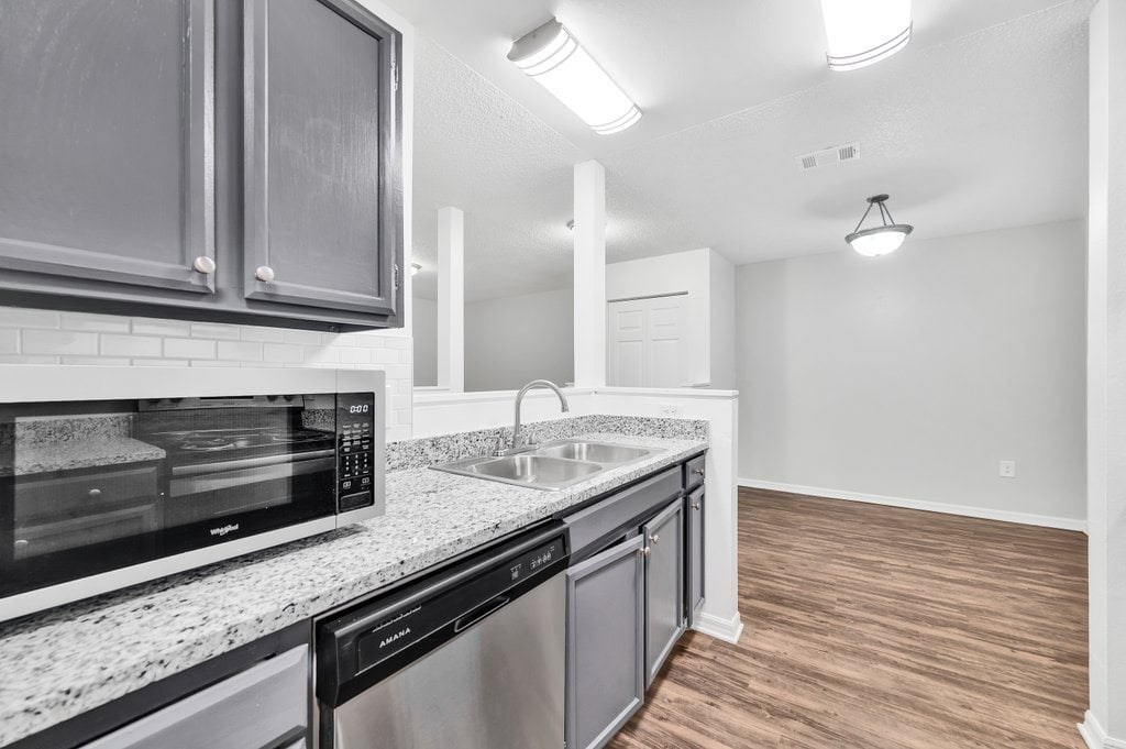 a renovated kitchen with granite counter tops and stainless steel appliances