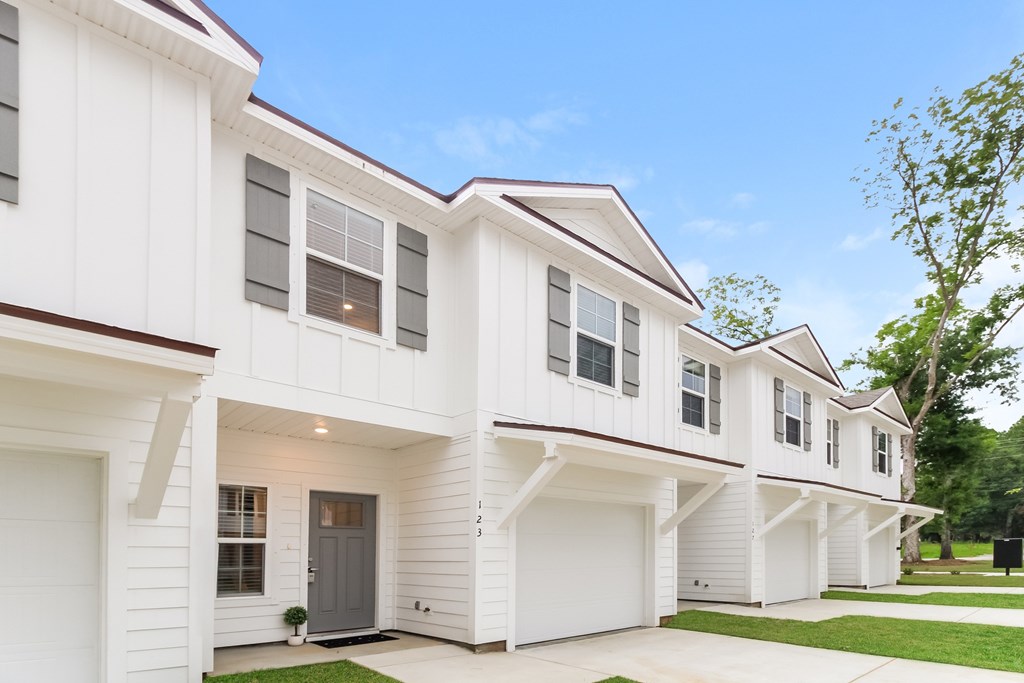 the exterior of a white home with gray doors and windows