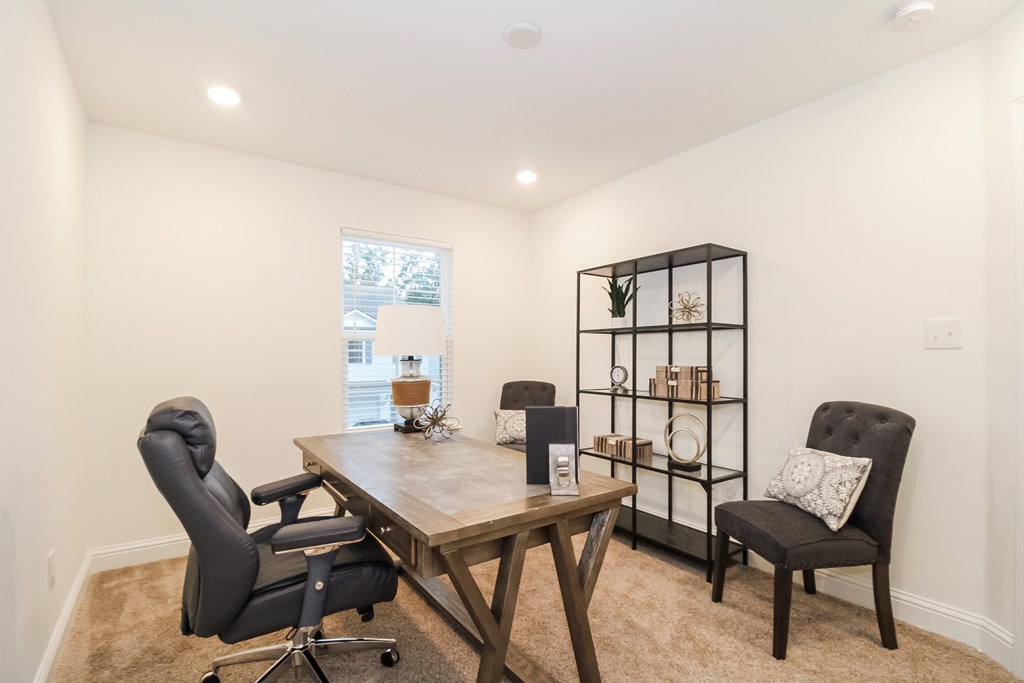 a home office with a wooden desk and chairs