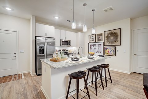 a kitchen with a counter top with three stools