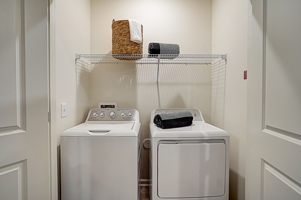a washer and dryer in a laundry room with a shelf over the was
