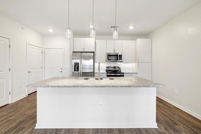 a kitchen with white cabinets and a granite counter top