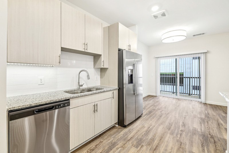 a kitchen with a stainless steel refrigerator and a sink