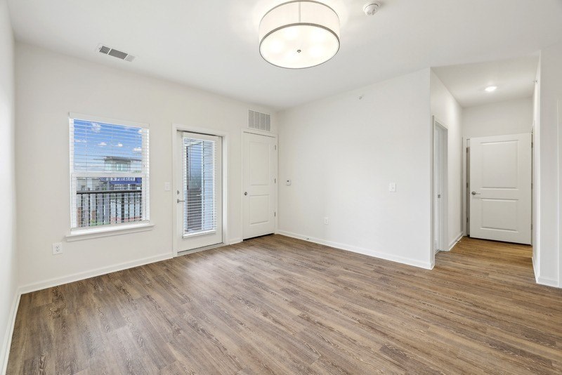 an empty living room with white walls and wood flooring