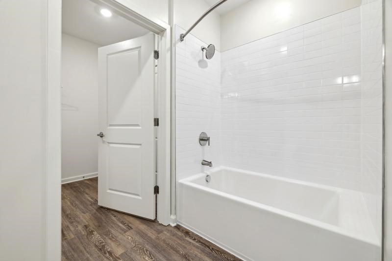 a white bathroom with a tub and a shower