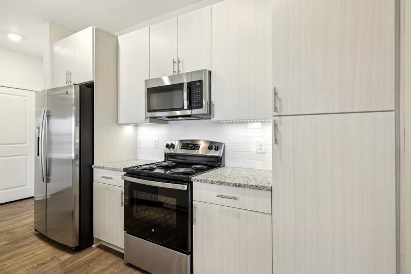 a white kitchen with a stove and a microwave
