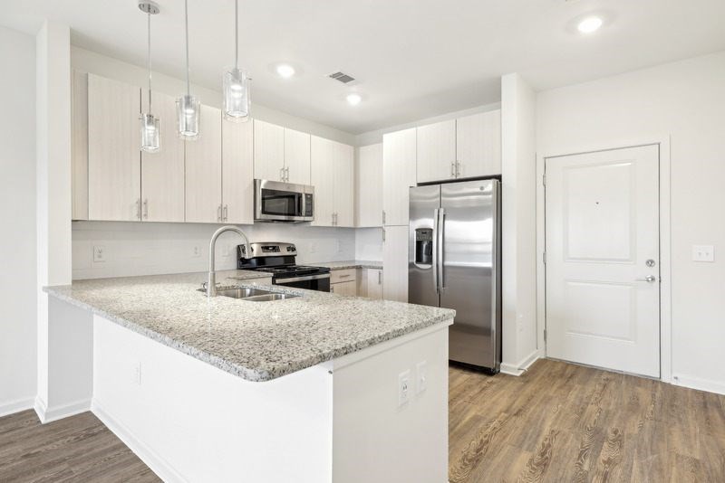 a kitchen with a granite counter top and a stainless steel refrigerator
