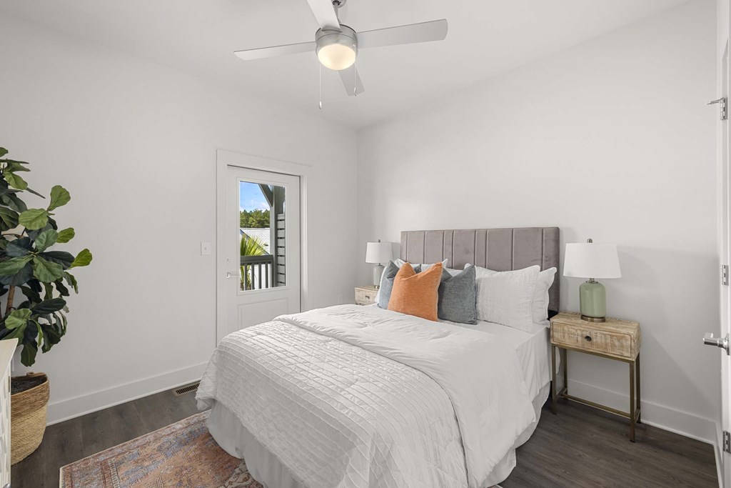 a white bedroom with a bed and a ceiling fan