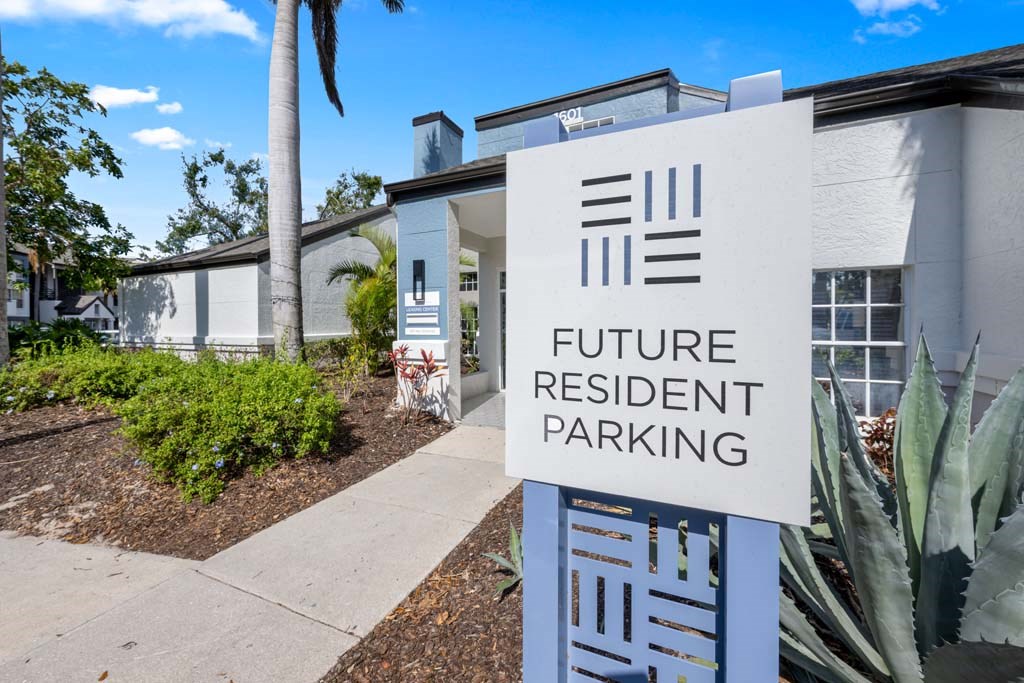 a white building with a sign in front of it for future resident parking