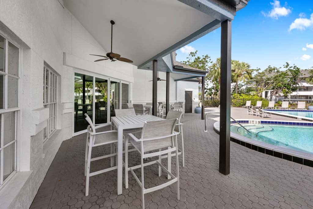 a patio with a table and chairs next to a pool