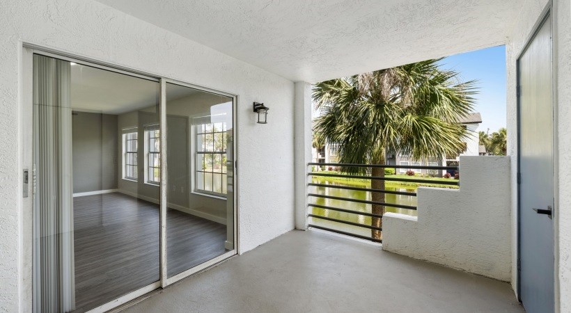a balcony with a view of a palm tree