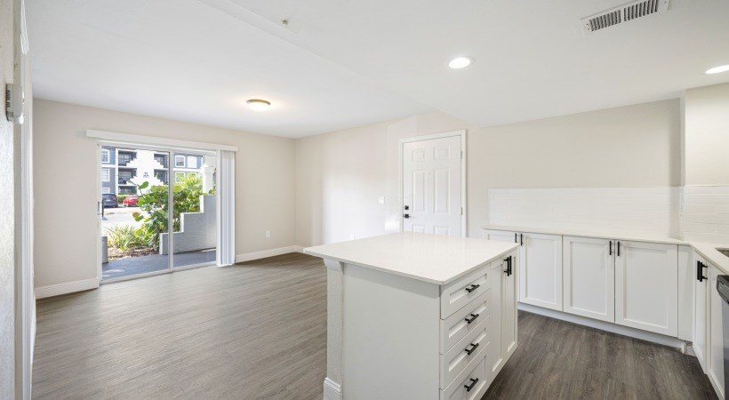 a kitchen with white cabinets and a white counter top in a house