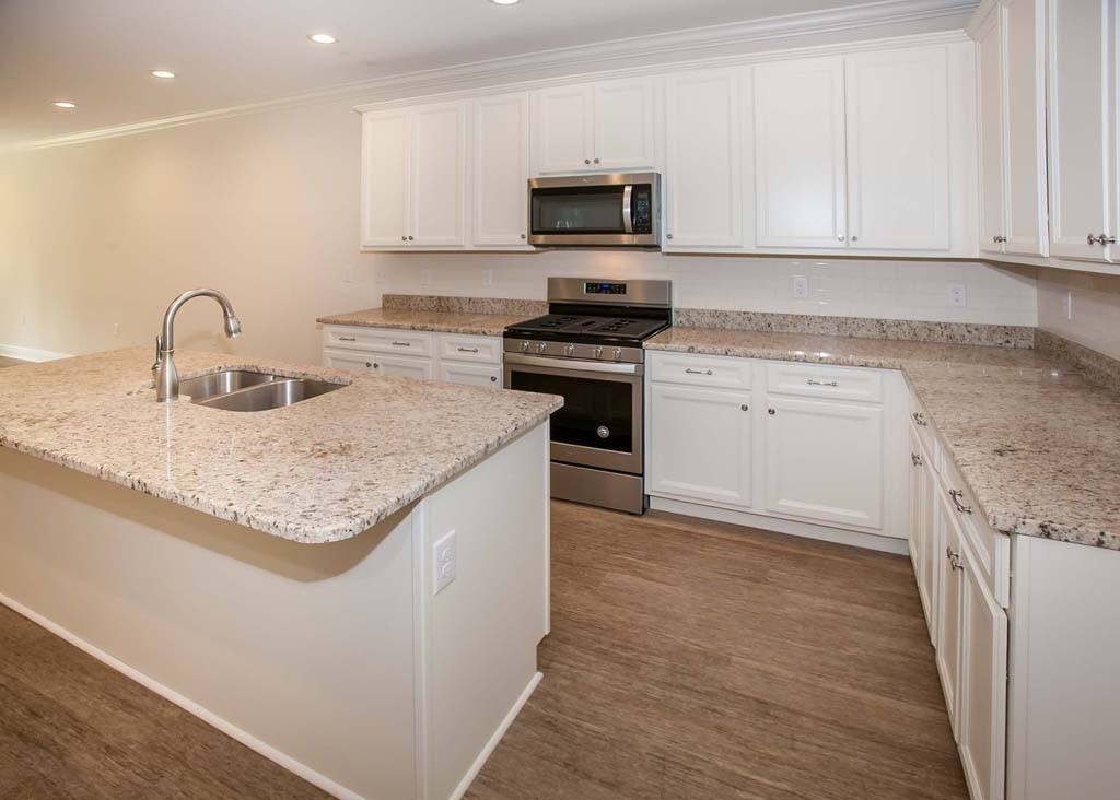 a kitchen with white cabinets and granite counter tops