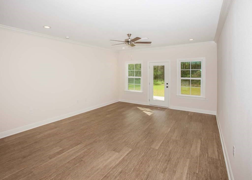 an empty living room with a ceiling fan and a window