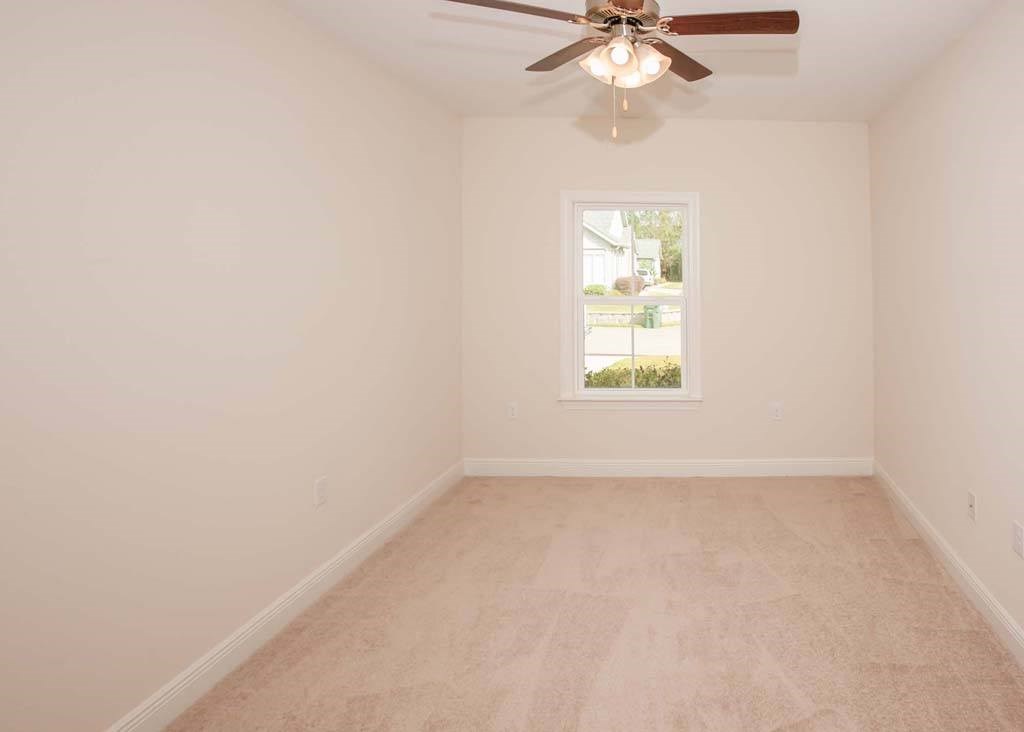 a empty room with a ceiling fan and a window