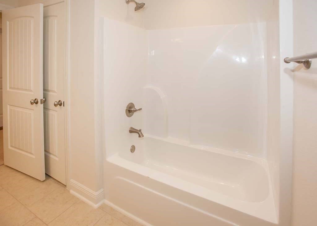 a white bath tub in a bathroom with a door