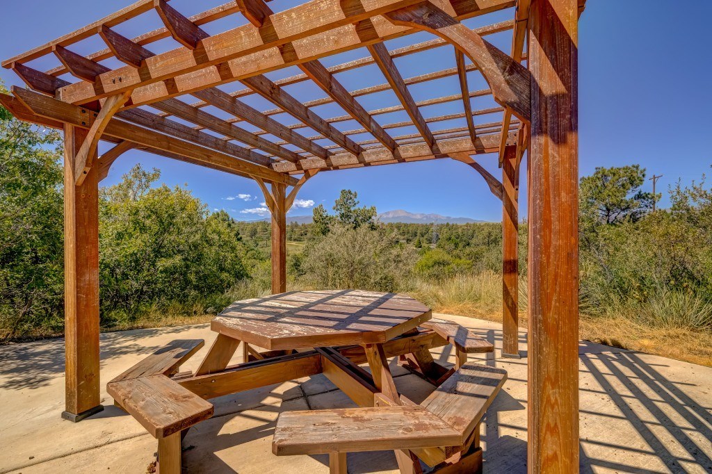 a picnic table with benches under a wooden structure