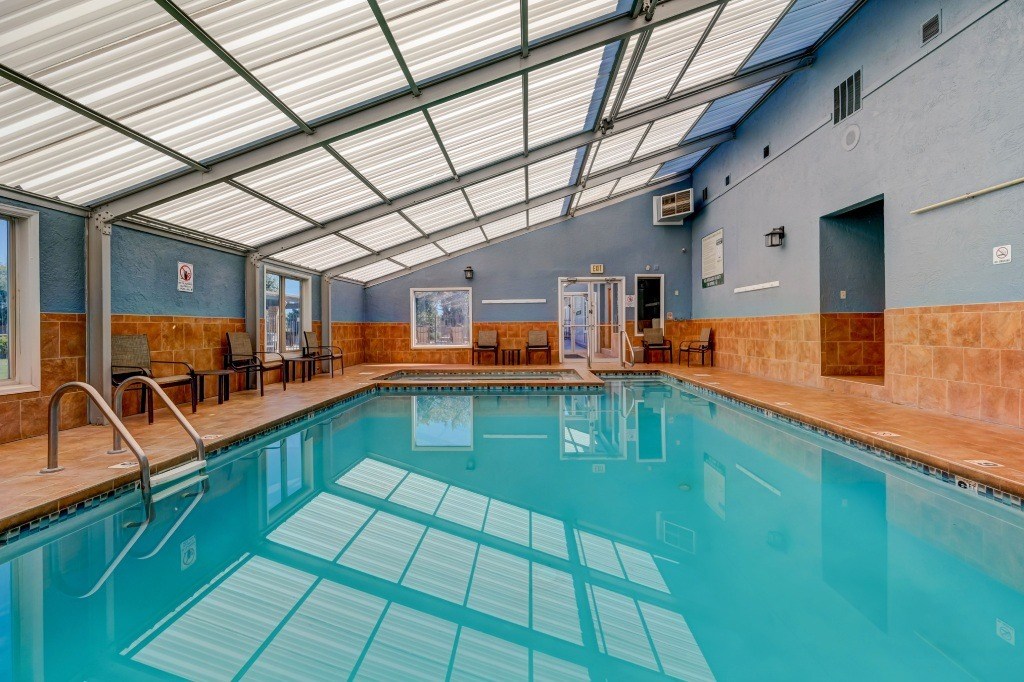 a swimming pool under a glass ceiling in a hotel room
